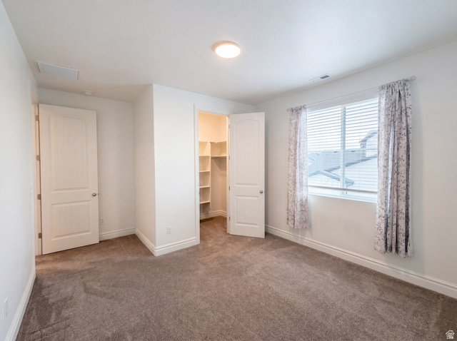 1251 North 2525 West Clinton, UT 84015 - Photo 4 of 30 Carpeted room featuring a window with blinds, white trim, a flush mount ceiling light, and a built-in closet with shelving