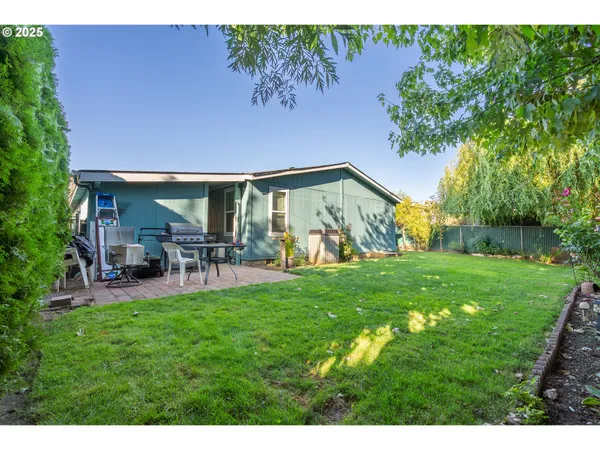a backyard of a house with table and chairs