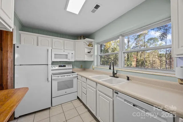 a kitchen with white cabinets and white appliances