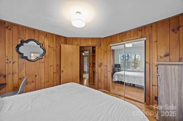 a bedroom with a bed and a closet with mirror