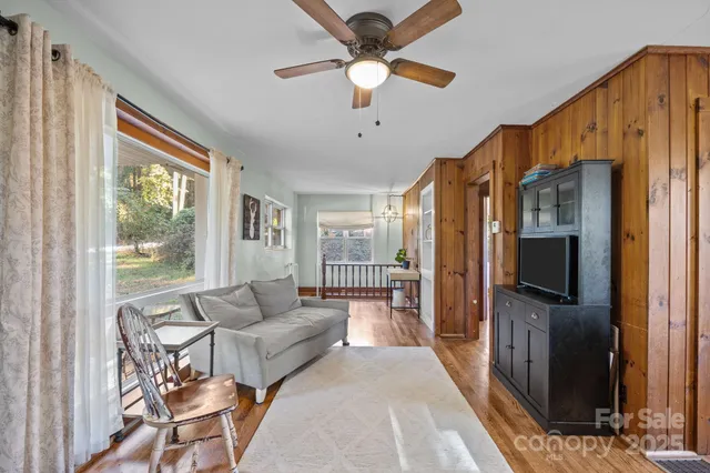 a living room with furniture a flat screen tv and a window