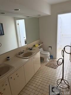 1117 Cedar Ridge Road Oyster Bay, NY 11771 - Photo 12 of 41 a bathroom with a sink a toilet and a mirror