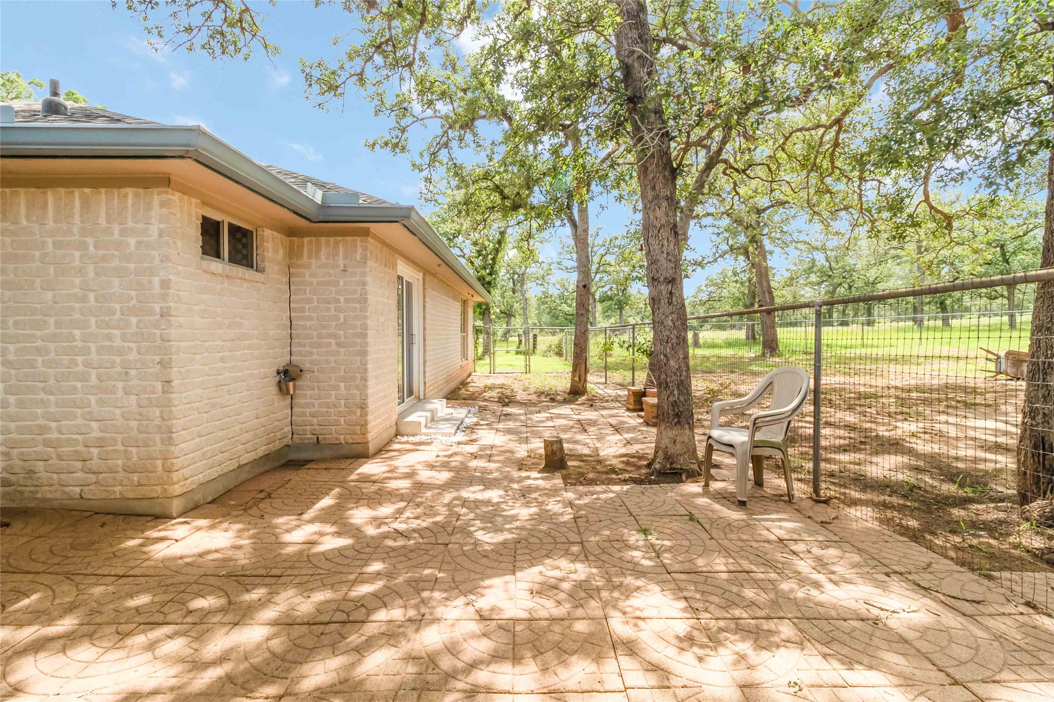 1208 Jeddo Road Rosanky, TX 78953 - Photo 34 of 40 A private, shaded patio offers serene views of the fenced-in yard, perfect for quiet enjoyment.