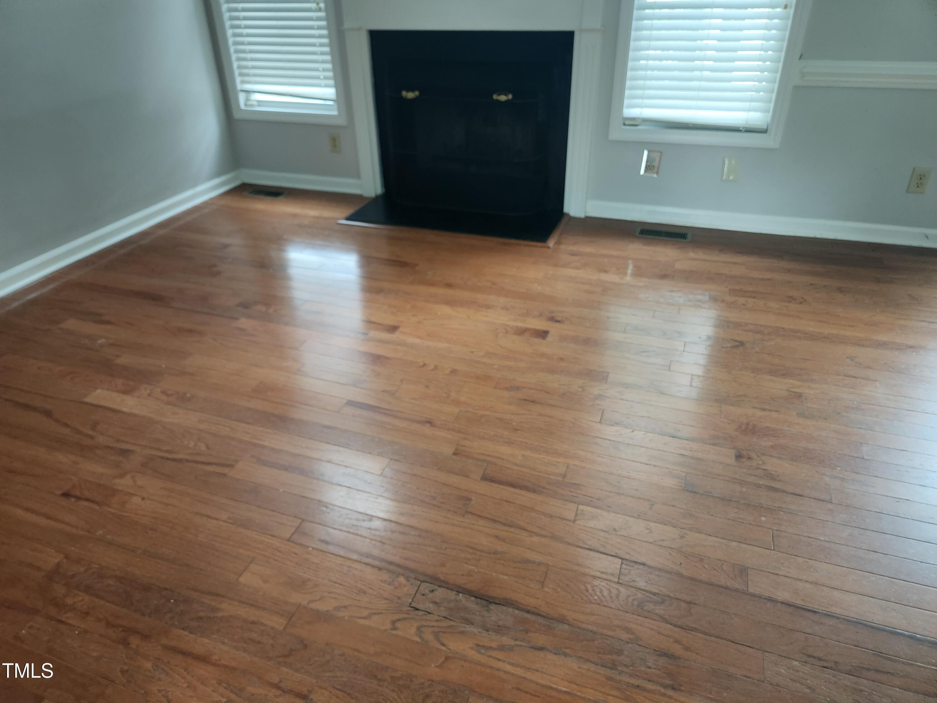709 Thistlegate Trail Raleigh, NC 27610 - Photo 13 of 40 an empty room with wooden floor and windows