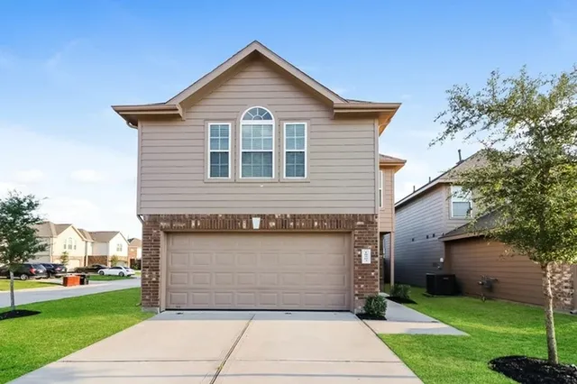 a front view of a house with a yard and garage