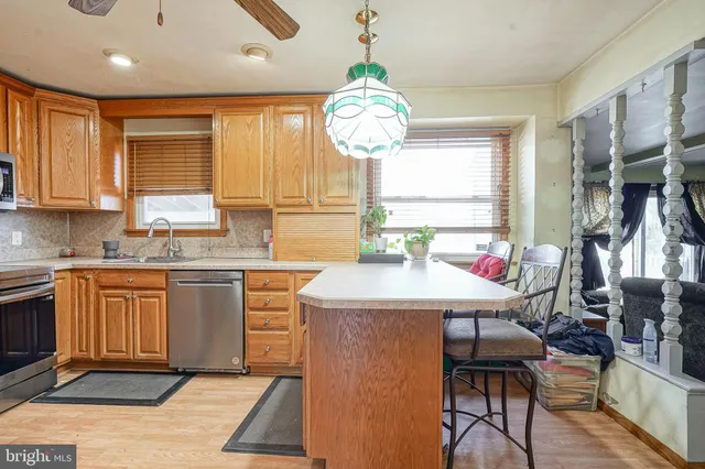 a kitchen with stainless steel appliances granite countertop a stove top oven cabinets a dining table and chairs with wooden floor