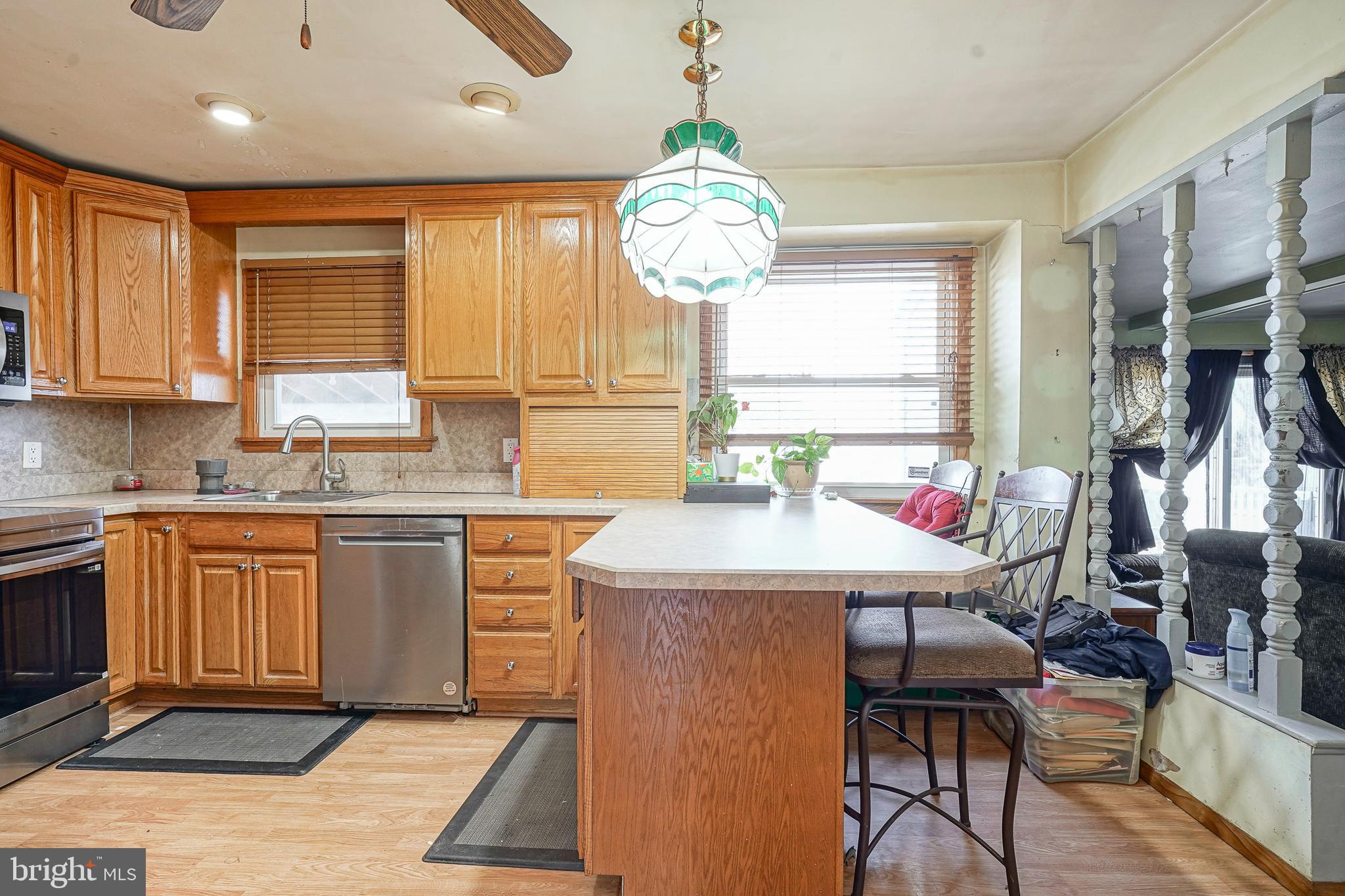 1638 Red Oak Road Williamstown, NJ 08094 - Photo 4 of 23 a kitchen with stainless steel appliances granite countertop a stove top oven cabinets a dining table and chairs with wooden floor