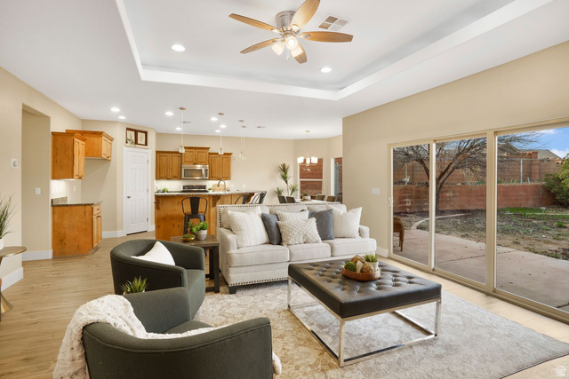 1570 South Rio Virgin Drive Washington, UT 84780 - Photo 15 of 71 Living room with light wood-style flooring, ceiling fan, a tray ceiling, and a chandelier