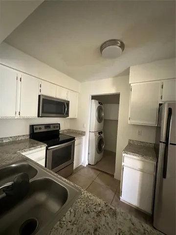 a kitchen with a refrigerator microwave and sink