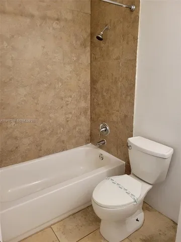 a white toilet sitting next to a bath tub and a shower