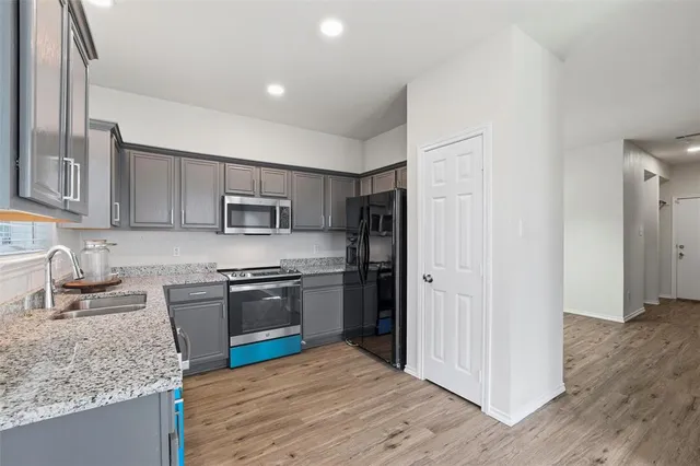 a kitchen with stainless steel appliances granite countertop a refrigerator stove and sink