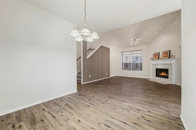 a view of a livingroom with a fireplace a ceiling fan and windows