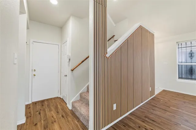 a view of a hallway with wooden floor and staircase