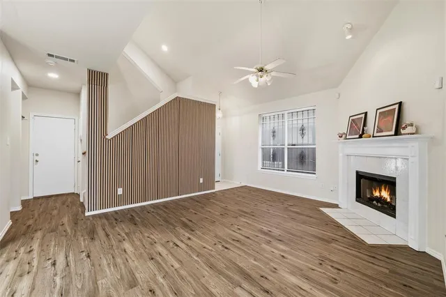 a view of empty room with wooden floor and fireplace