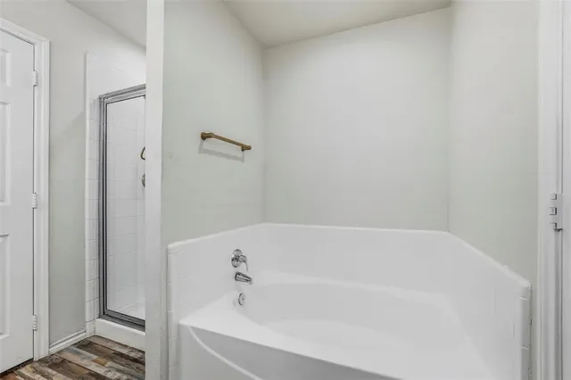 a white bath tub sitting next to a shower