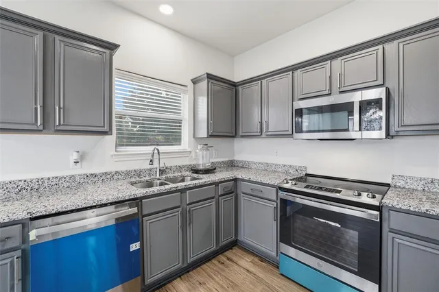 a kitchen with stainless steel appliances granite countertop a sink stove and microwave