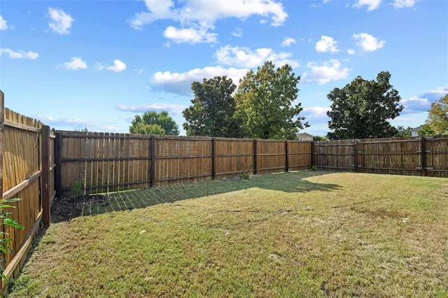a view of backyard with wooden fence