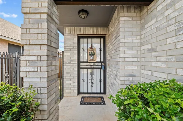 a front view of a building with a garden and plants