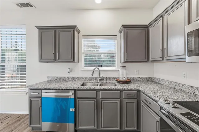a kitchen with stainless steel appliances granite countertop a sink stove and cabinets