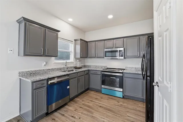 a kitchen with granite countertop stainless steel appliances and wooden cabinets