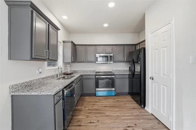 a kitchen with stainless steel appliances granite countertop a stove top oven a sink and dishwasher