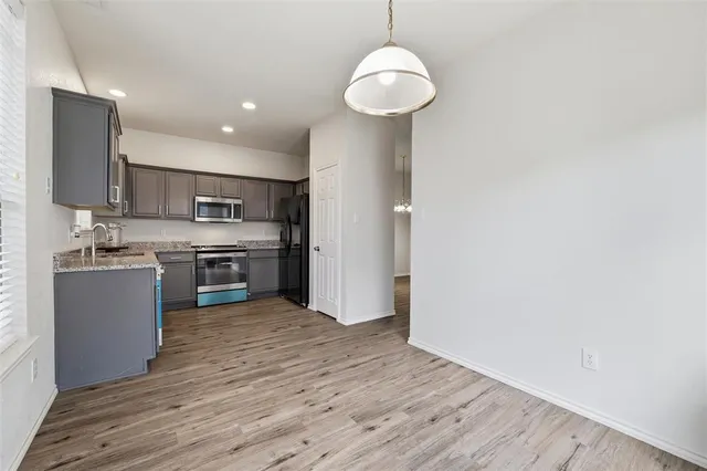 a kitchen with stainless steel appliances granite countertop a sink and a refrigerator