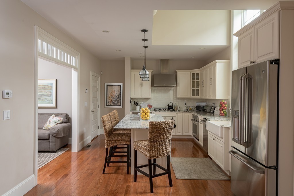 10 Backriver Road, Unit 10 Hingham, MA 02043 - Photo 4 of 30 a kitchen with a refrigerator a dining table and chairs