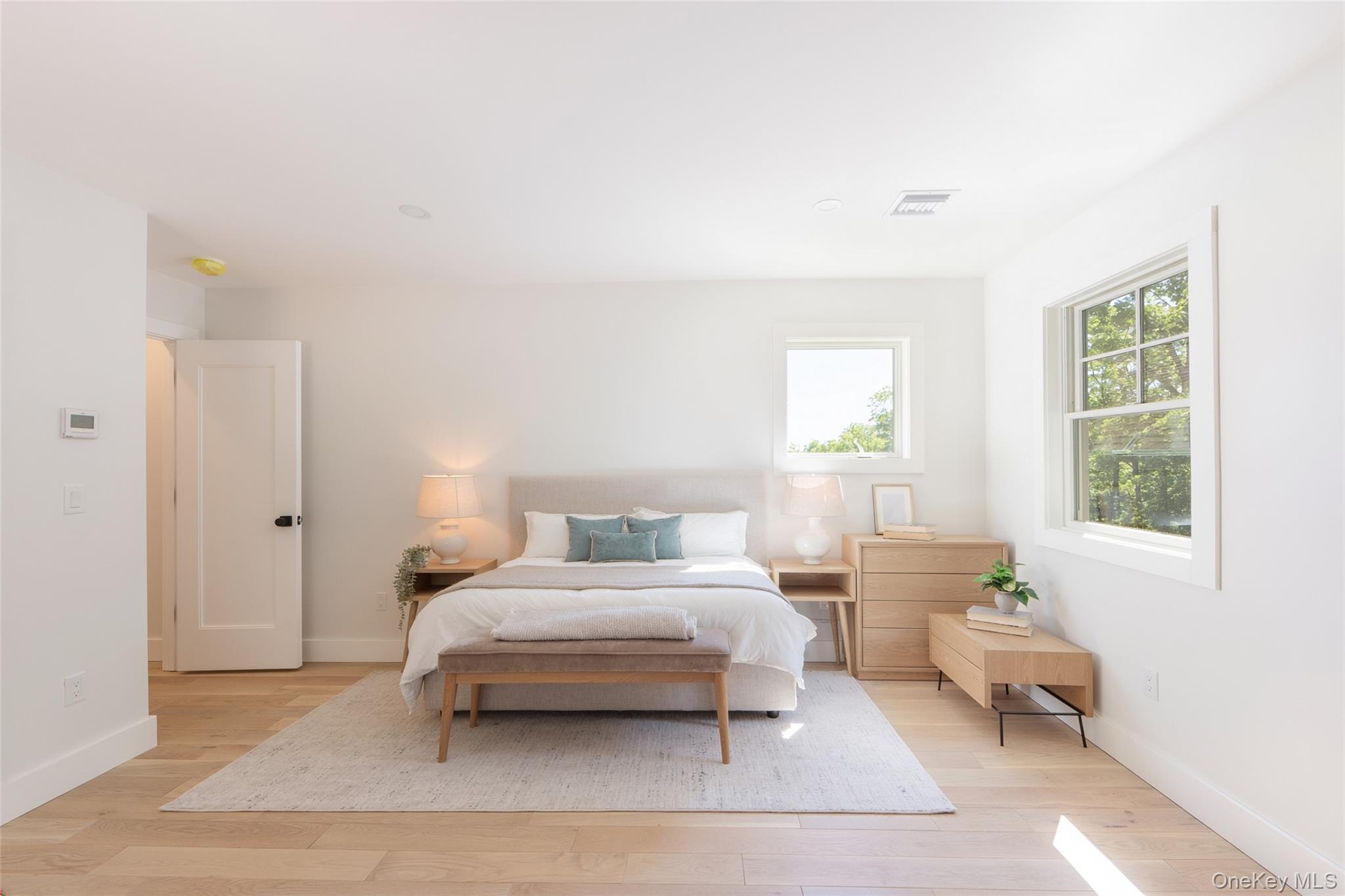 91 Lenni Lenape Road Narrowsburg, NY 12764 - Photo 15 of 25 Bright bedroom featuring light wood-finish flooring, white walls, and multiple windowsImages have been virtually staged to illustrate the property's potential
