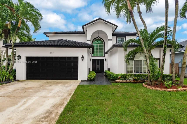 a front view of a house with a garden and trees