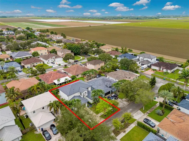 an aerial view of ocean and residential houses with outdoor space