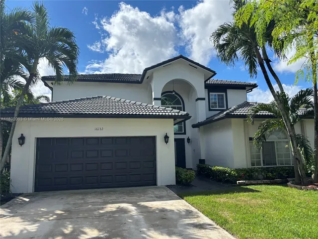 a front view of a house with a yard and garage