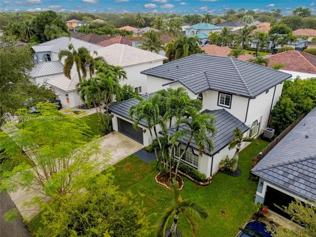 an aerial view of a house with garden space and street view