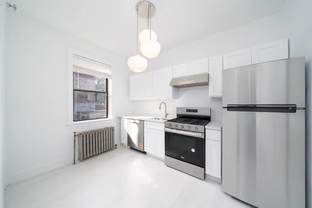 a kitchen with stainless steel appliances granite countertop a sink a stove and refrigerator