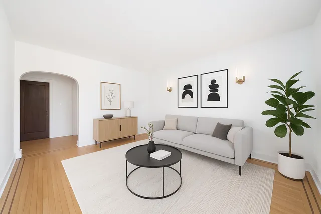 a living room with furniture potted plant and wooden floor