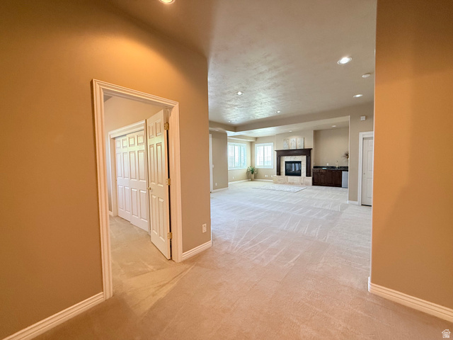 1562 Fairway Ridge Road Draper, UT 84020 - Photo 36 of 60 Spacious room with plush carpeting, recessed lighting, and a prominent fireplace featuring a dark wood mantel and light-toned stone surround