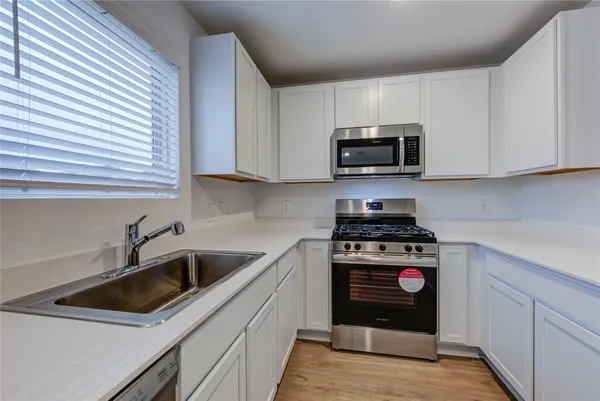 a kitchen with sink a microwave and stove