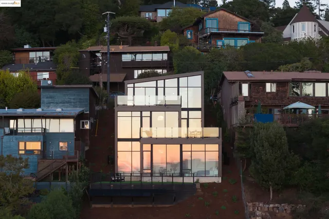 a view of a brick house with many windows and plants