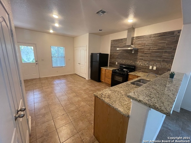 434 Tequila Ranch San Antonio, TX 78245 - Photo 6 of 21 a kitchen with stainless steel appliances kitchen island granite countertop a refrigerator and a sink