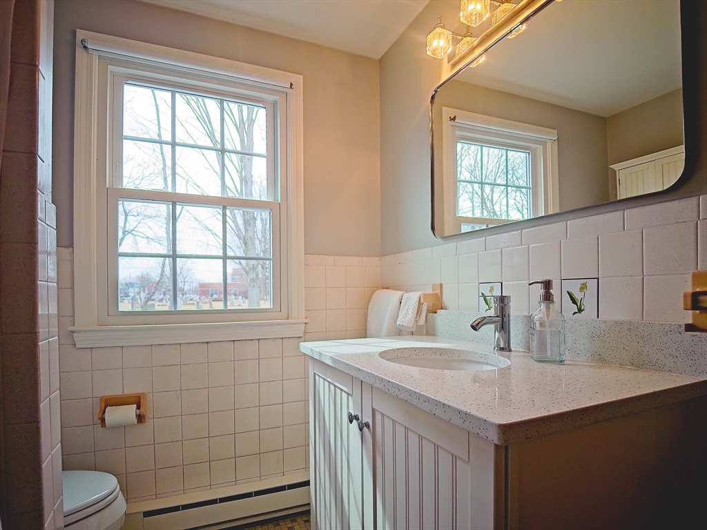 57 Sylvan Street, Unit 5D Danvers, MA 01923 - Photo 13 of 15 a bathroom with a sink toilet and vanity