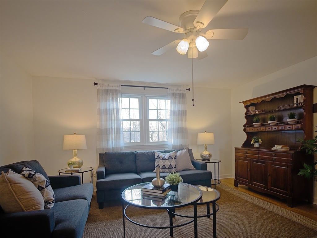 57 Sylvan Street, Unit 5D Danvers, MA 01923 - Photo 2 of 15 a living room with furniture a fireplace and a flat screen tv