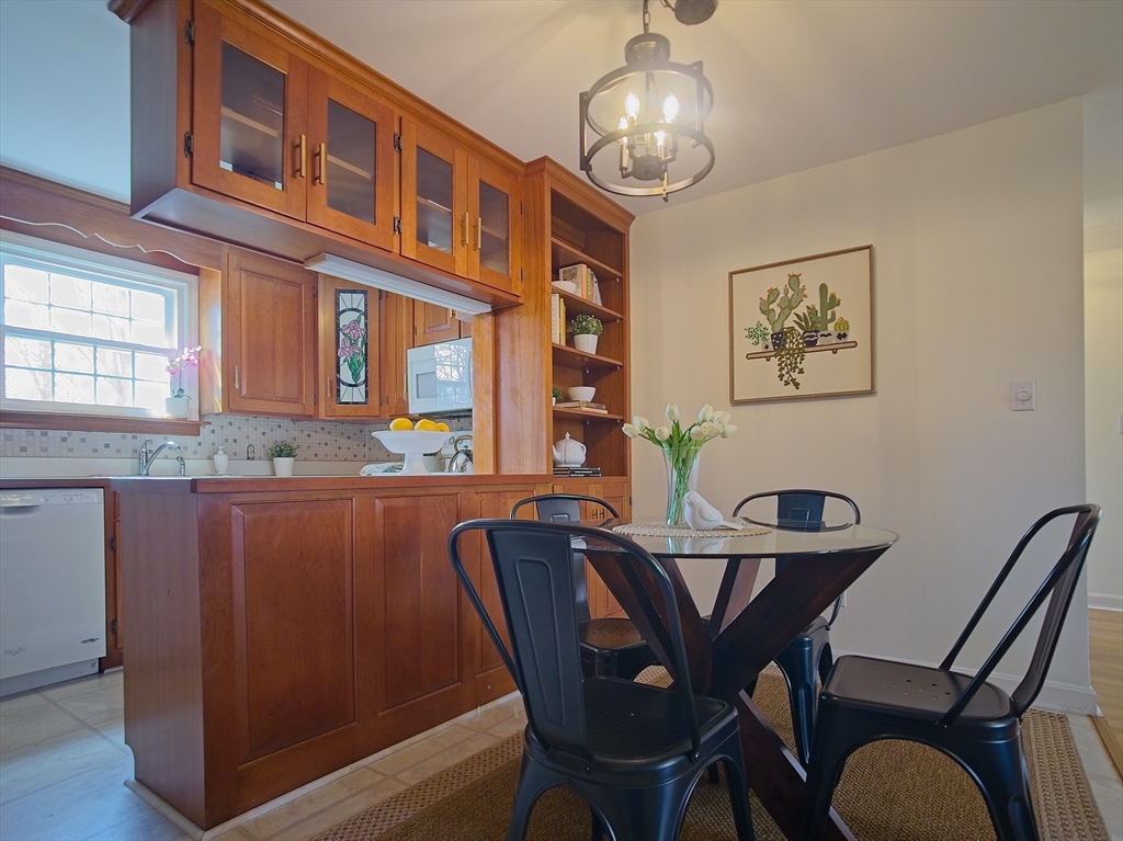 57 Sylvan Street, Unit 5D Danvers, MA 01923 - Photo 5 of 15 a view of a dining room with furniture wooden floor and chandelier