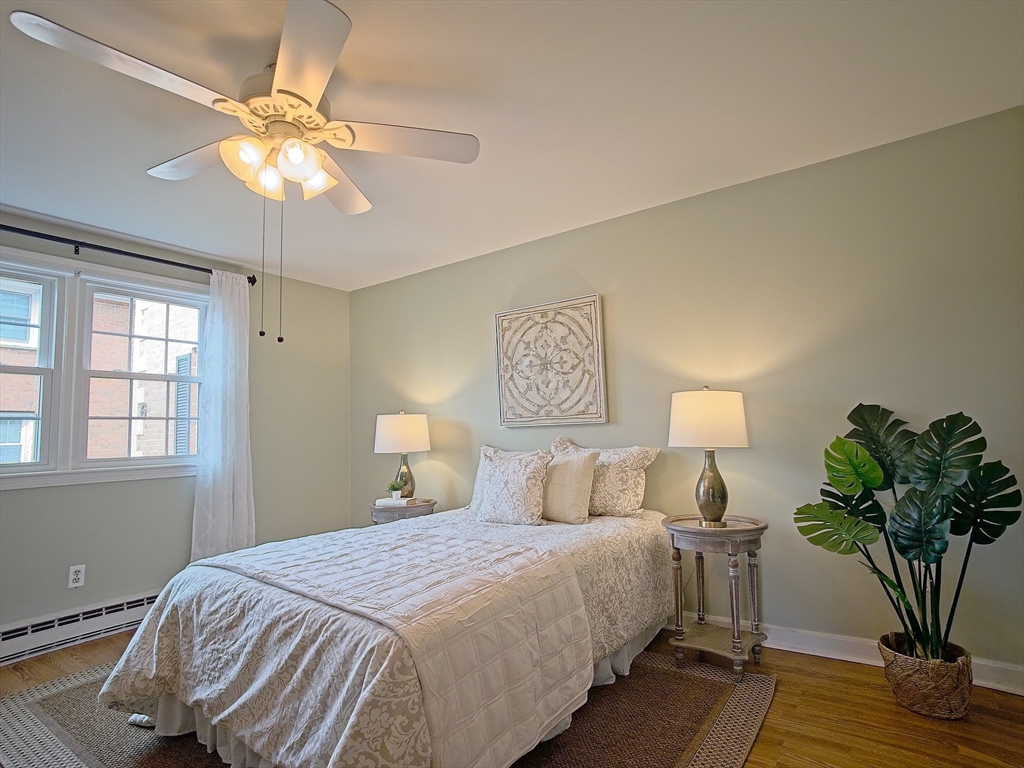57 Sylvan Street, Unit 5D Danvers, MA 01923 - Photo 8 of 15 a bedroom with a bed and a chandelier