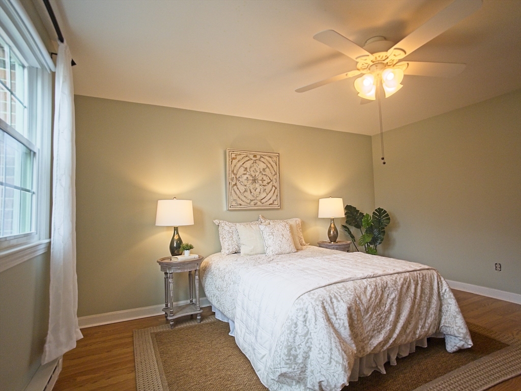 57 Sylvan Street, Unit 5D Danvers, MA 01923 - Photo 9 of 15 a bedroom with a bed and a chandelier