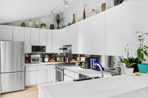 a kitchen with refrigerator and cabinets