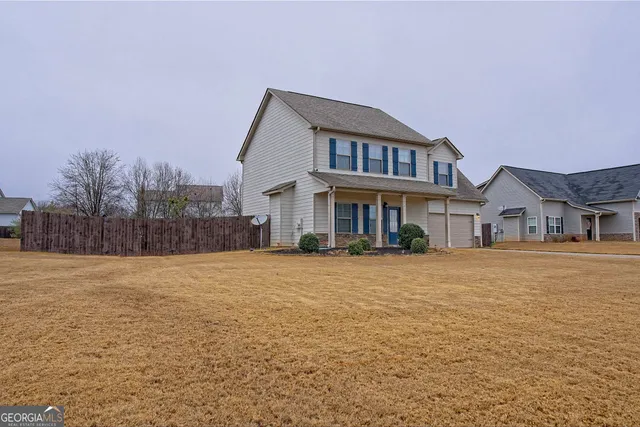 a front view of a house with a yard and trees