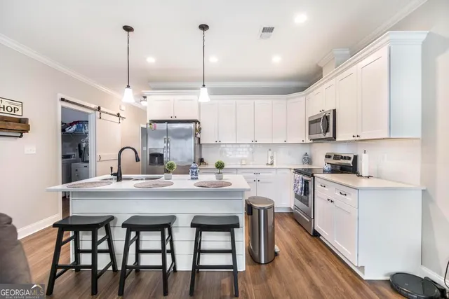 a kitchen with kitchen island a white counter space a sink appliances and cabinets