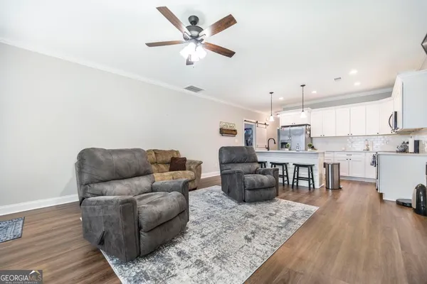 a living room with furniture and kitchen view