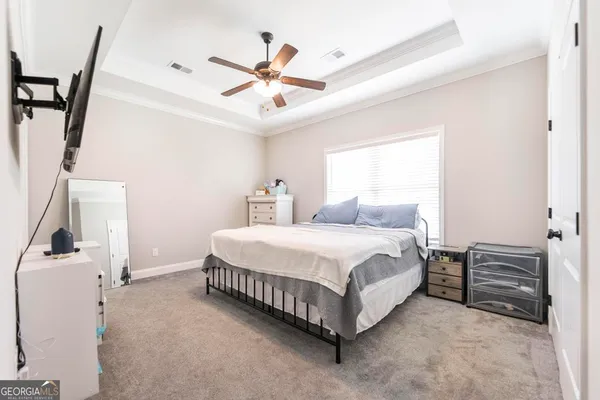 a spacious bedroom with a bed and a ceiling fan