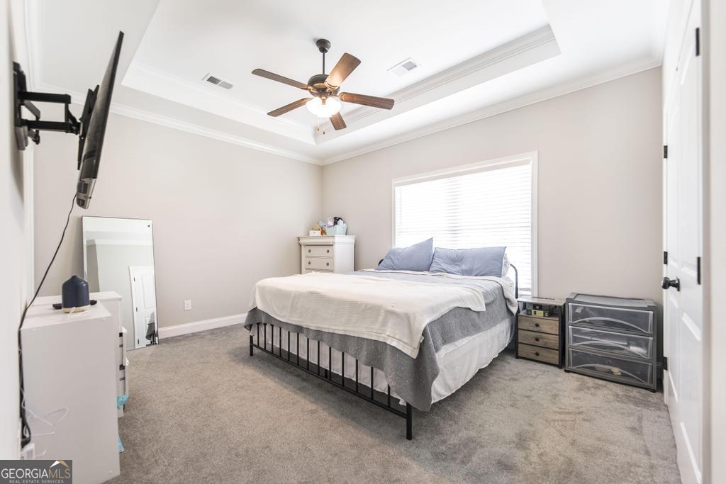 309 Charles Gray Boulevard Perry, GA 31069 - Photo 18 of 30 a spacious bedroom with a bed and a ceiling fan