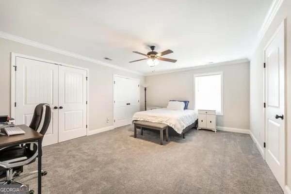 a spacious bedroom with a bed a desk and chair